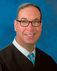 Smiling man wearing judicial robe
