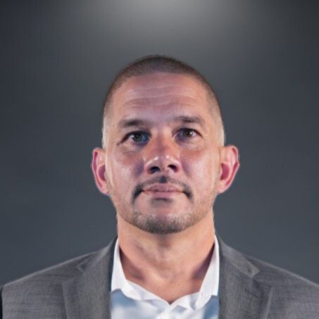 a man with facial hair posting for the camera